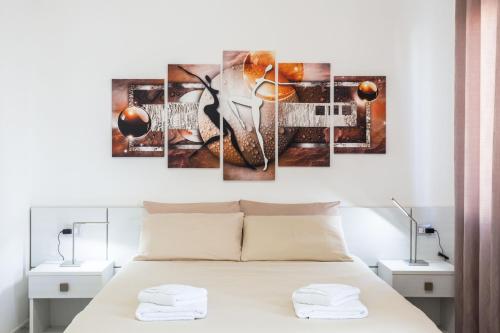 a room with a bed with a wall art picture at Nùe Rooms in Cagliari