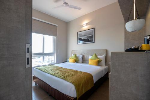 a bedroom with a large bed with yellow pillows at Hotel Avora Tree By Rivido Kempegowda Airport Road in Bangalore