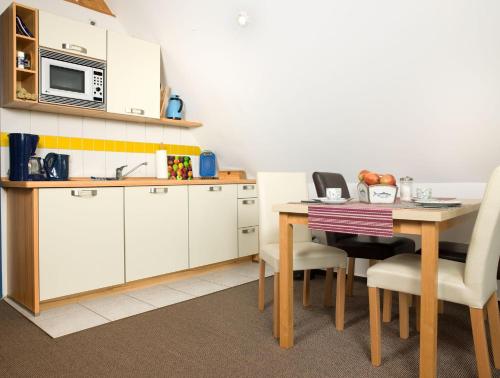 uma cozinha com uma mesa e um micro-ondas em Haus Meerforelle Haus Meerforelle Wohnung 2 em Insel Poel