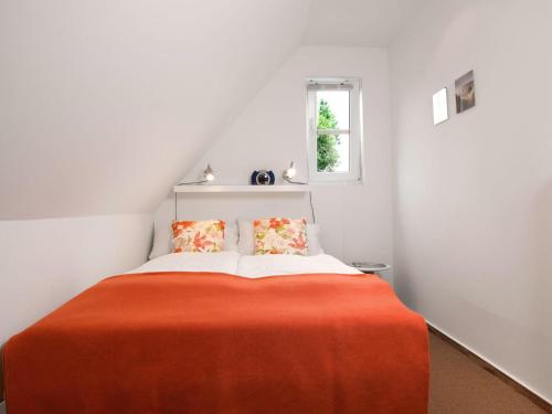 um quarto com uma cama com um cobertor laranja em Haus Meerforelle Haus Meerforelle Wohnung 2 em Insel Poel