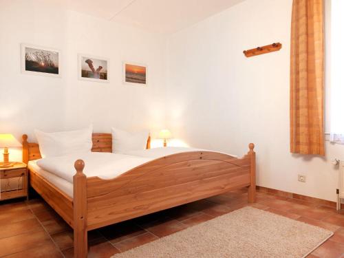 a bedroom with a wooden bed in a room at Buchenweg Schwalbennest in Insel Poel