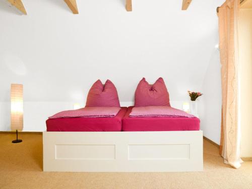 a white bed with purple pillows on top of it at Haus Gestrandet in Kaltenhof