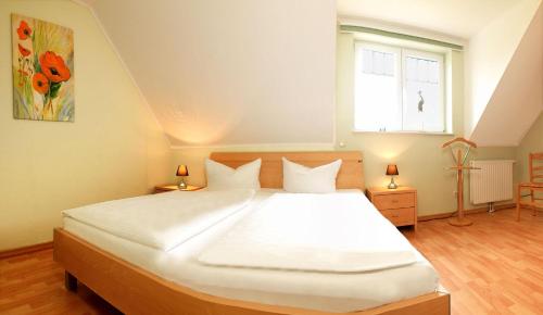sypialnia z dużym białym łóżkiem i oknem w obiekcie Reihenhäuser Timmendorf Strand Haus Sonnenaufgang w mieście Wyspa Poel