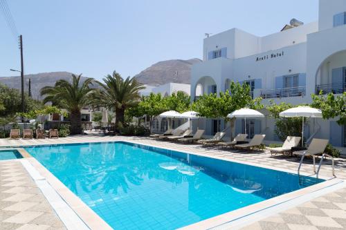 a pool at a hotel with chairs and umbrellas at Areti Hotel in Kamari