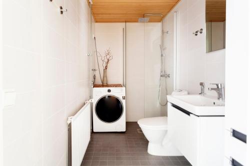 y baño con aseo y lavadora. en 2ndhomes Design Apartment in Kamppi, en Helsinki