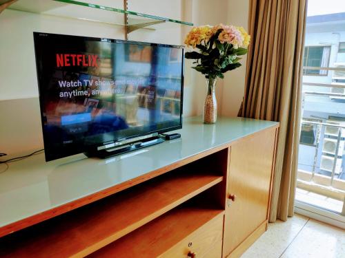 En tv och/eller ett underhållningssystem på Quiet studio with king bed, kitchen and balcony