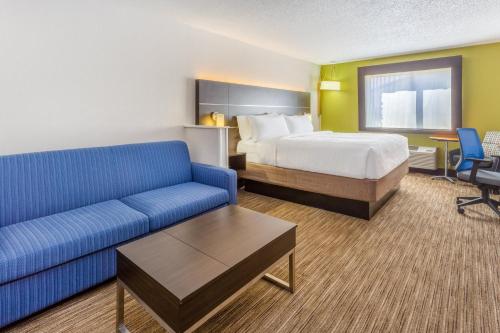 ein Hotelzimmer mit einem Bett und einem Sofa in der Unterkunft Holiday Inn Express Columbus - Ohio Expo Center, an IHG Hotel in Columbus