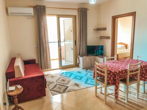 ein Wohnzimmer mit einem Tisch und ein Zimmer mit Aussicht in der Unterkunft MiMi's Beach Apartment in Vlorë