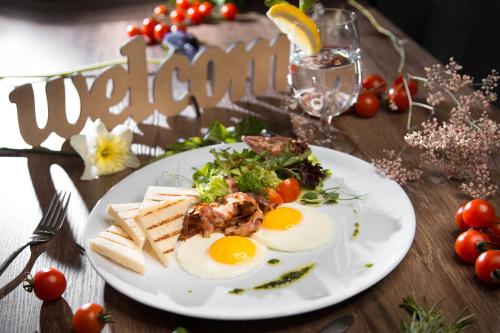 a plate of food with eggs and bread on a table at Favor Sport Hotel in Kyiv