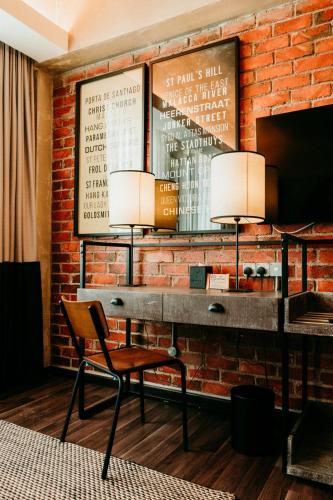 a brick wall with a desk and a chair at Rosa Malacca in Melaka
