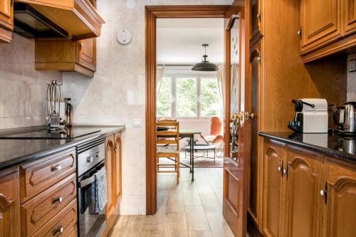 a kitchen with wooden cabinets and a table at Cozy Apartment With Splashes Of Color in Hospitalet de Llobregat