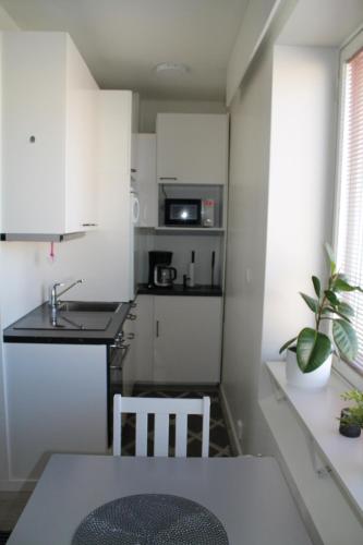 a small kitchen with a table and a sink at Valtakatu 2 in Pori