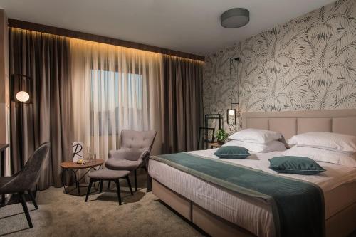 a bedroom with a bed and a table and a chair at Rosslyn Central Park Hotel Sofia in Sofia
