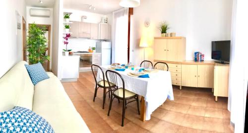une cuisine et une salle à manger avec une table et des chaises dans l'établissement Grazioso appartamento a due passi dal mare, à Cervia