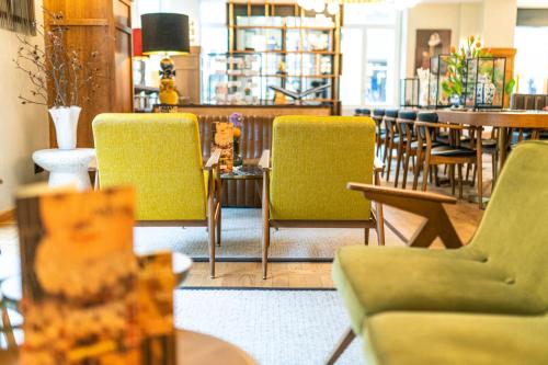 a restaurant with yellow chairs and tables and tablesearcher at The Collector in The Hague