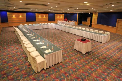 a banquet hall with rows of tables and white chairs at Holiday Inn Monterrey-Parque Fundidora by IHG in Monterrey