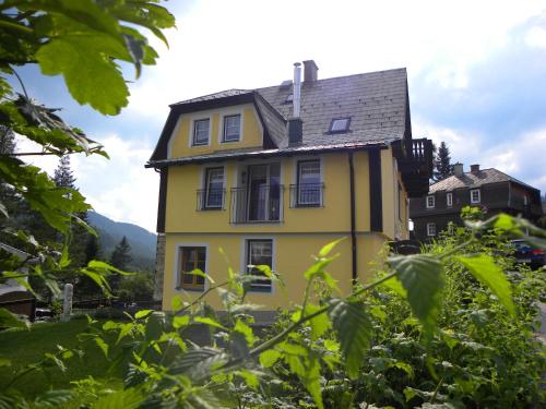 a yellow house with a black roof at Landhaus Semmering in Semmering