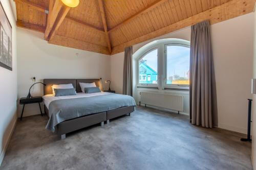 ein Schlafzimmer mit einem Bett und einem großen Fenster in der Unterkunft Grasse 140 - Kustpark Village Scaldia in Hoofdplaat