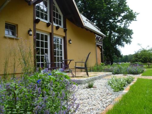 a garden in front of a house with purple flowers at Froschkönig - Ferienhaus und Ferienwohnungen 03096 Burg Spreewald in Burg