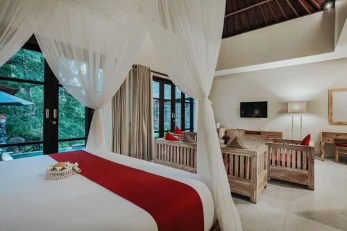 a bedroom with a bed and a crib and a desk at Kawi Resort Ubud in Tegalalang