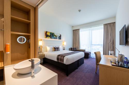 a hotel room with a bed and a bathroom at Premier Inn Dubai Dragon Mart in Dubai