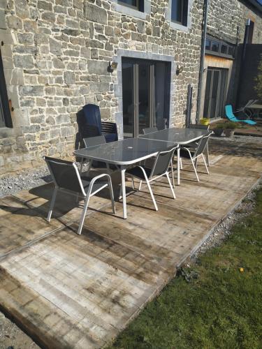 une table et des chaises assises sur une terrasse en bois dans l'établissement Gîtes du tellin, à Couvin