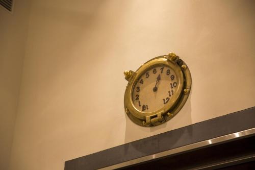 a gold clock hanging on a wall at Hotel Monterey Kobe in Kobe
