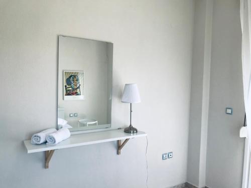een spiegel aan een muur met handdoeken op een plank bij Dimeli 1 in Plaka Litochorou