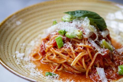 a plate of spaghetti with sauce and green onions at Hotel Monterey Kobe in Kobe