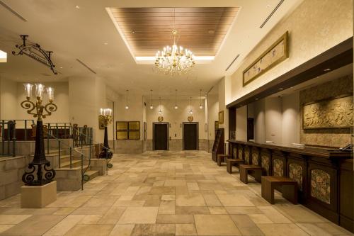 a lobby with a chandelier and a hallway with benches at Hotel Monterey Kobe in Kobe