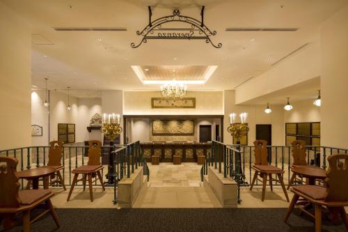 a lobby with tables and chairs and a chandelier at Hotel Monterey Kobe in Kobe