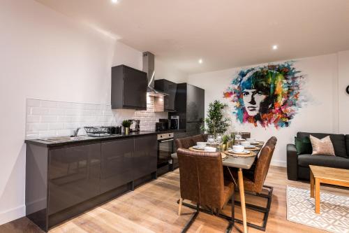 a kitchen and living room with a table and a couch at SGT Peppers Mathew Street Apartments By Happy Days in Liverpool
