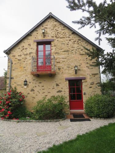 a building with a red door and a window at Ecrin de Verdure in Sainte-Suzanne