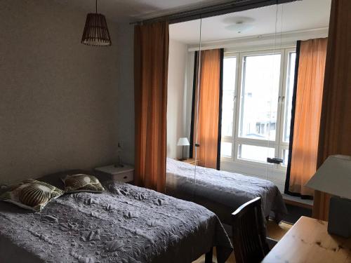 a bedroom with two beds and a large window at Vaasa Apartments 4 in Vaasa