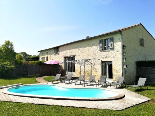 a swimming pool in the yard of a house at Domaine du Grand Tourtre in Chalais