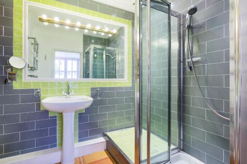 a bathroom with blue tiles and a sink and a shower at Veeve - South Kensington Garden Apartment in London