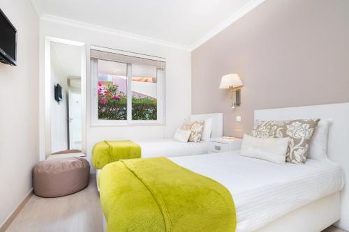 Un dormitorio blanco con una cama grande y una ventana. en WHome | Prime Hideaway Luxury Villa, en Quarteira