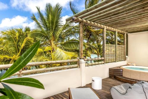 a balcony with a hot tub and palm trees at Lagoon Attitude (Adults Only) in Cap Malheureux