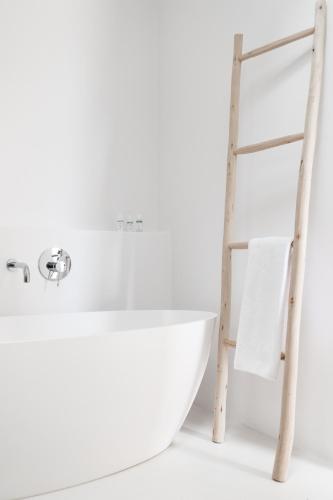a ladder next to a bath tub and a white sink at Torre Vella Fontenille Menorca in Son Bou