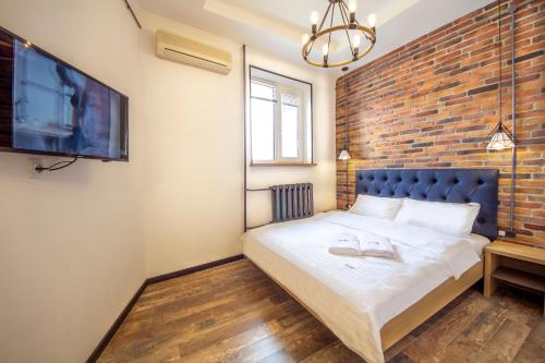 a bedroom with a brick wall and a bed at DayFlat Apartments Maidan Area in Kyiv