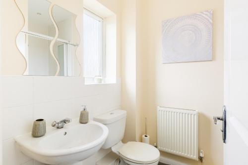 a white bathroom with a toilet and a sink at 5 Bedroom Home Stay in Wolverhampton