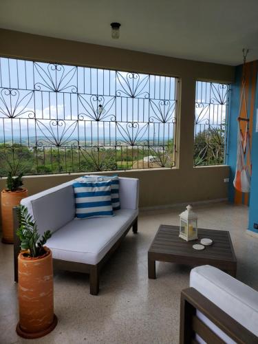 a living room with a couch and a large window at Kassa Wista Azzul-1 APARTMENT-NO POOL ACCESS-lower level OR Kassa Wista Azzul-2 House -upper floor- with EXCLUSIVE POOL ACCESS in Hormigueros