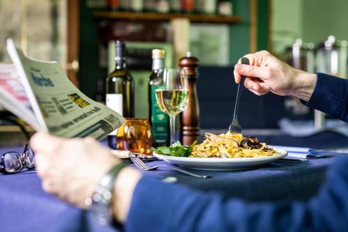 a person sitting at a table with a plate of food at Amadei Hotel Figaro & Apartments in Pesaro