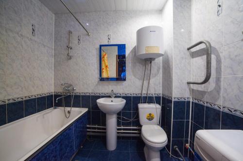 a bathroom with a toilet and a sink and a bath tub at Apartments KSGM London at Gamarnika 6A in Khabarovsk