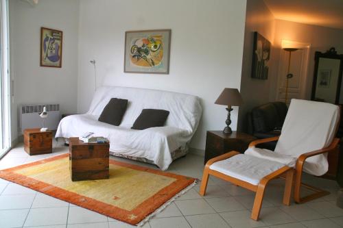 une chambre avec un lit, une chaise et une table dans l'établissement Comfortable house with pool, idyllic sight, golf, close to ocean, à Lacanau