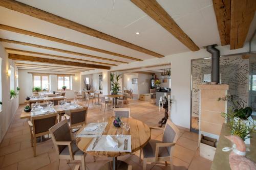 un ristorante con soffitti e tavoli in legno e sedie di La Maison Salvagny a Murten
