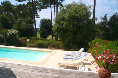 - deux chaises longues et une piscine dans l'établissement Comfortable house with pool, idyllic sight, golf, close to ocean, à Lacanau