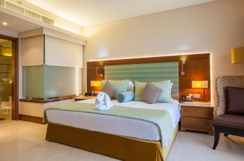 a bedroom with a large bed and a chair at Barceló Mussanah Resort, Sultanate of Oman in Mussanah