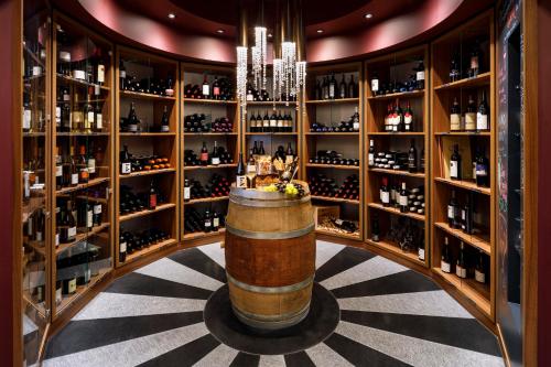 a wine cellar with a barrel and shelves of wine bottles at Märchenhotel in Braunwald