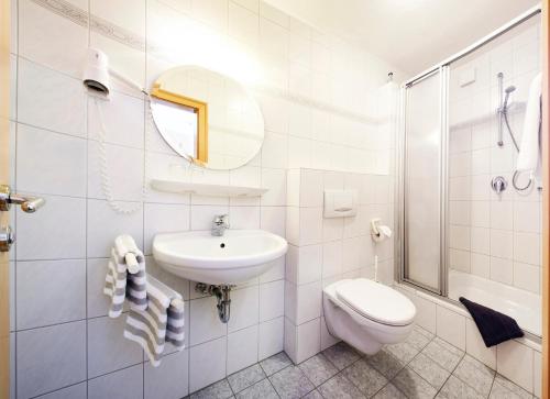 a white bathroom with a sink and a toilet at Hotel-Gasthof Zum Oberen Wirt in Regen